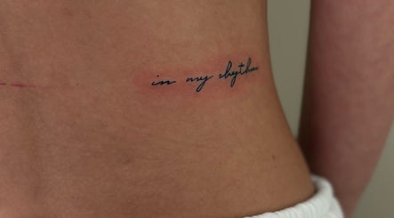 Elegant script tattoo saying 'in my rhythm' at Inklet Studio, Dunmow, England, GB.