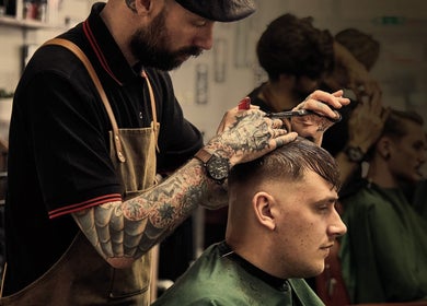 Barbiere all'opera da Alessio D’Auria ad Alessandria, Piemonte, IT, mentre esegue un taglio maschile moderno.