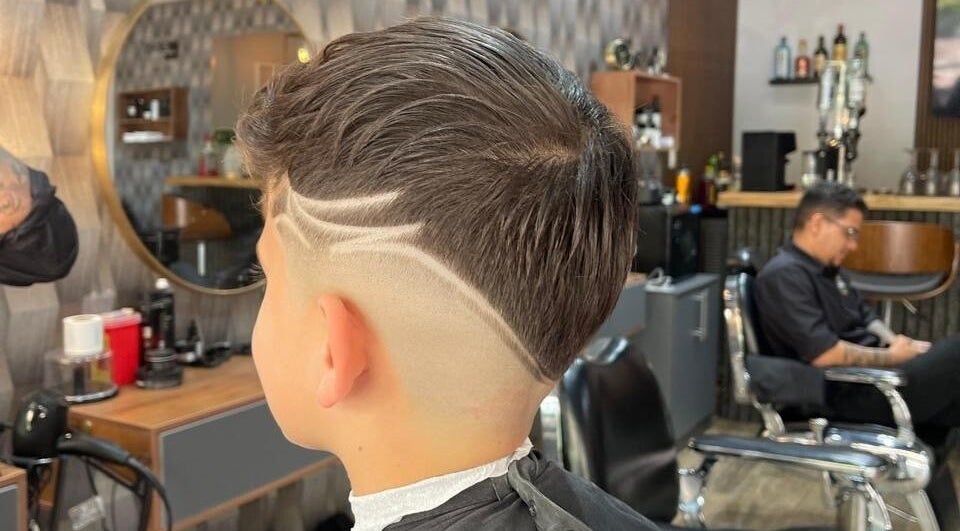 Corte de pelo moderno en Pacific Barbershop, Provincia De Panamá Oeste, destacando diseños afeitados únicos.