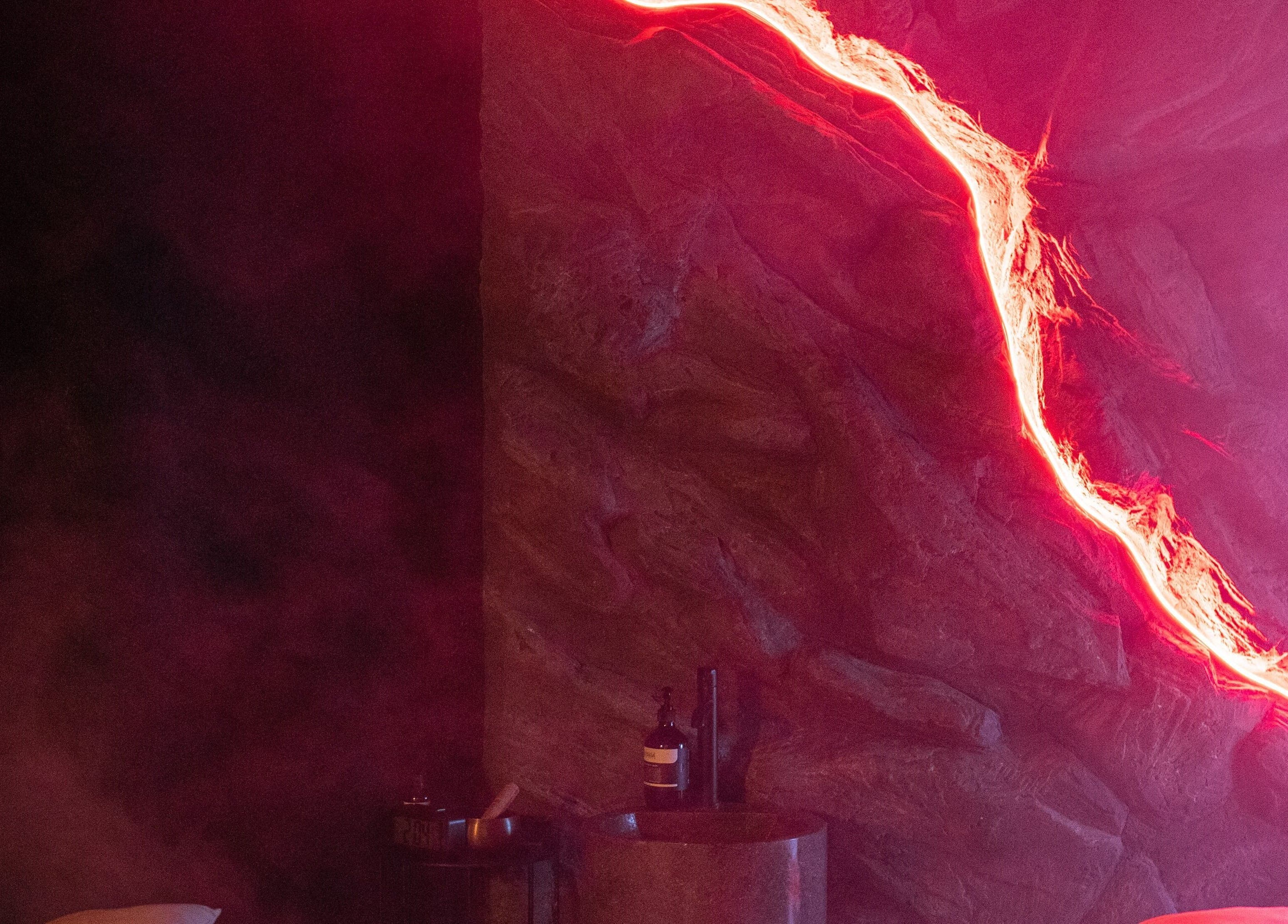 Интерьер спа с каменной стеной с красной подсветкой в Raya Spa, Бали, Бали, ID.