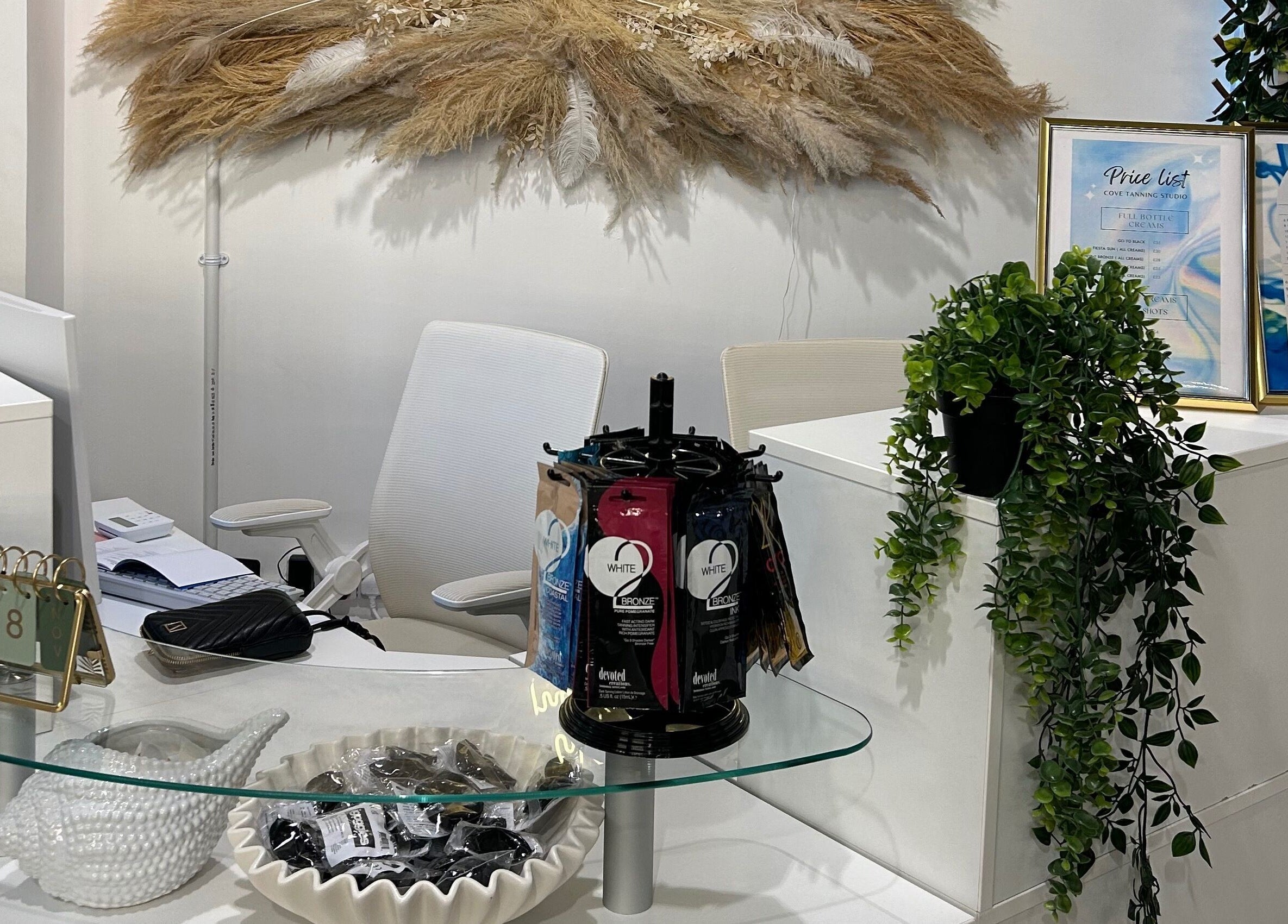 Reception area at Cove Tanning Studio, Droitwich Spa, England, GB, featuring modern decor and price list display.