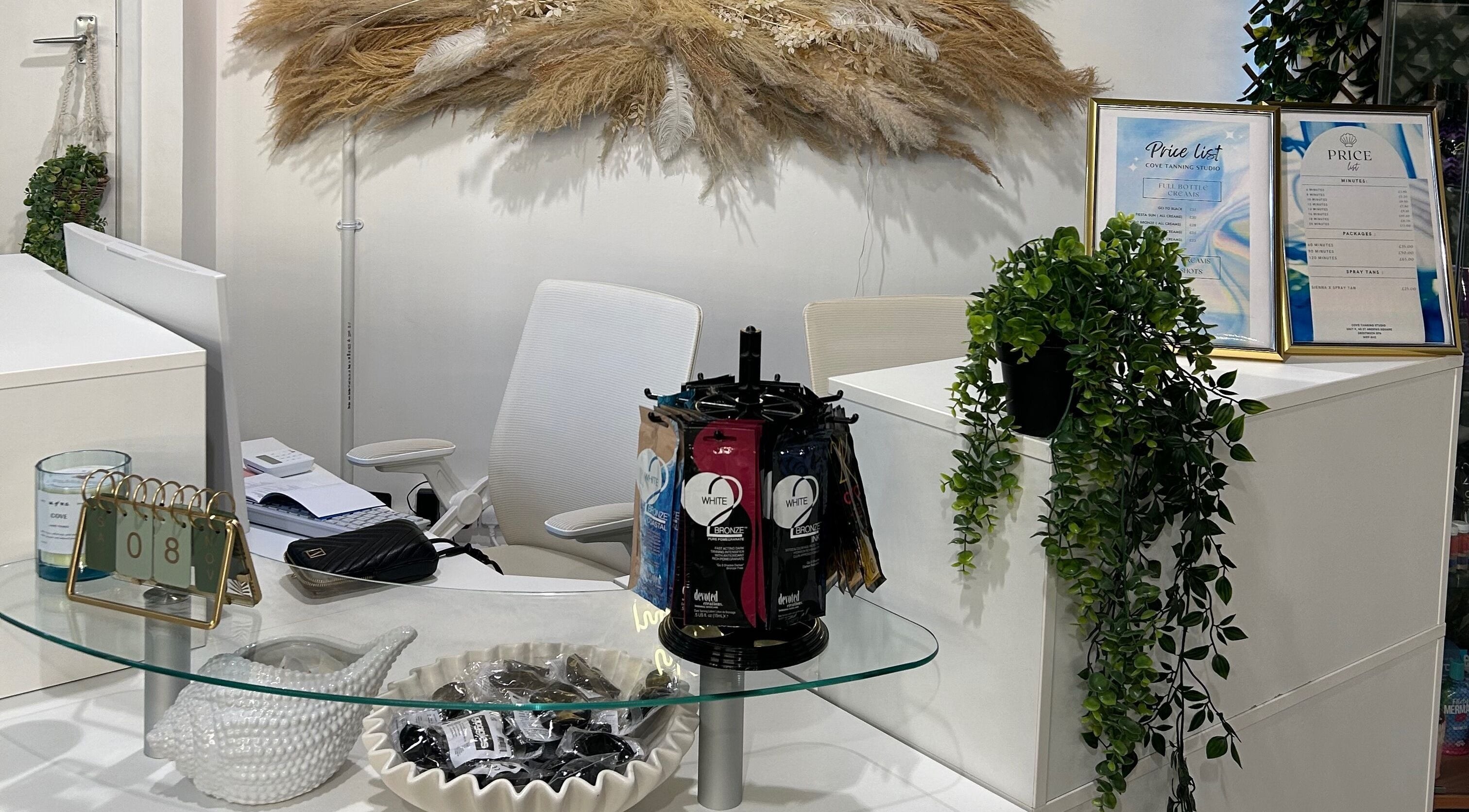 Reception area at Cove Tanning Studio, Droitwich Spa, England, GB, featuring modern decor and price list display.