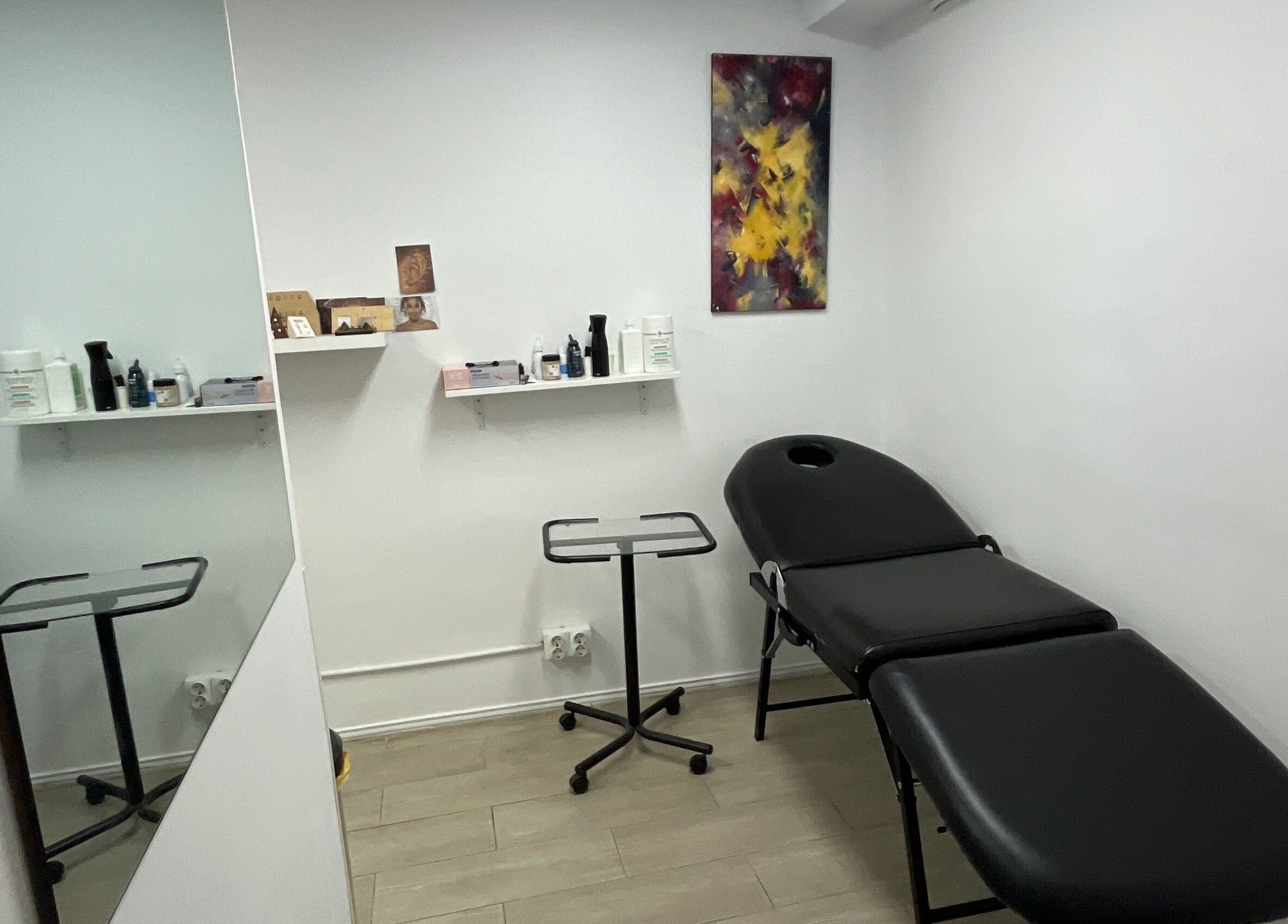 Nia ochoa's cozy wellness room in Barcelona, Barcelona, ES with a massage table and shelves with products.