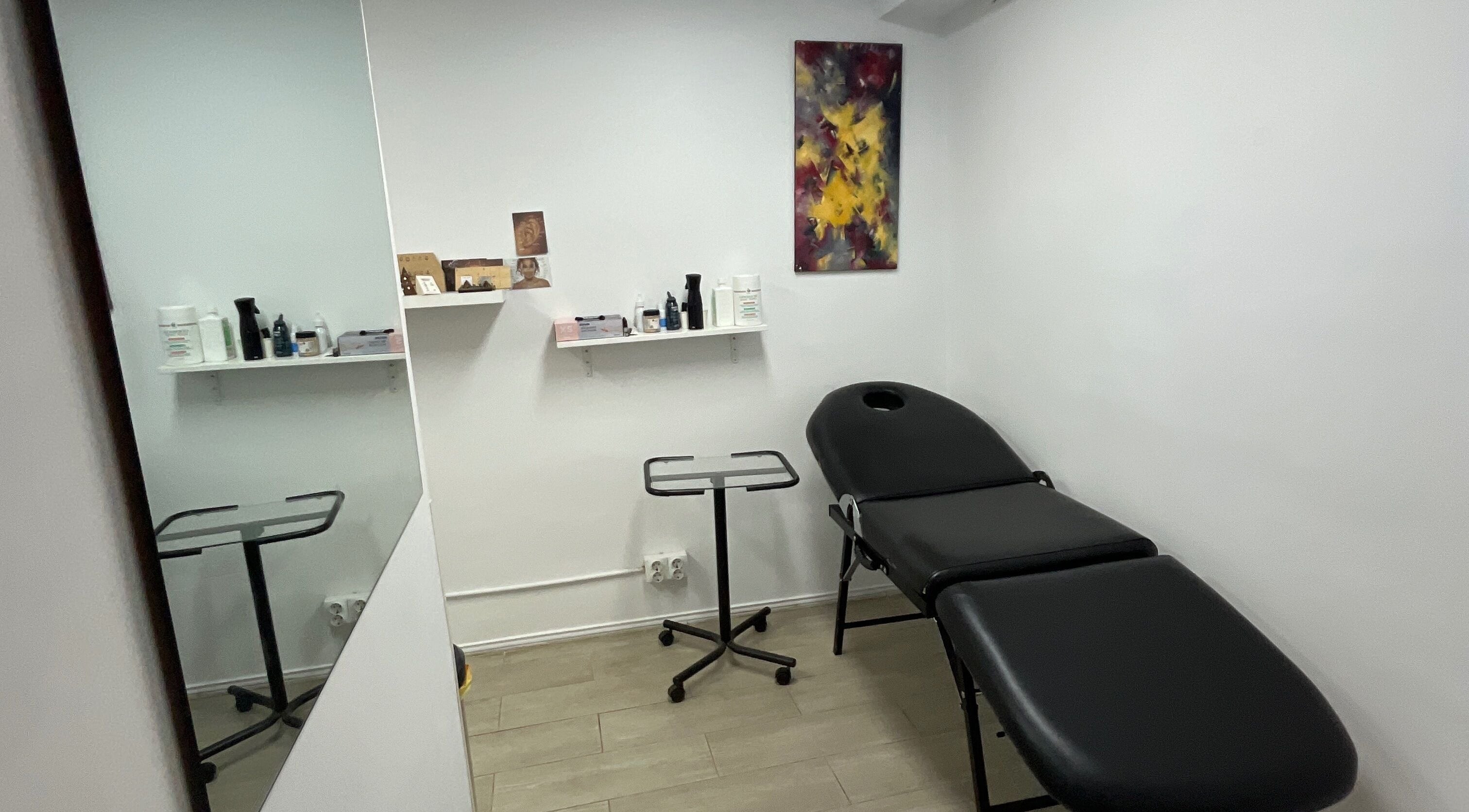 Nia ochoa's cozy wellness room in Barcelona, Barcelona, ES with a massage table and shelves with products.