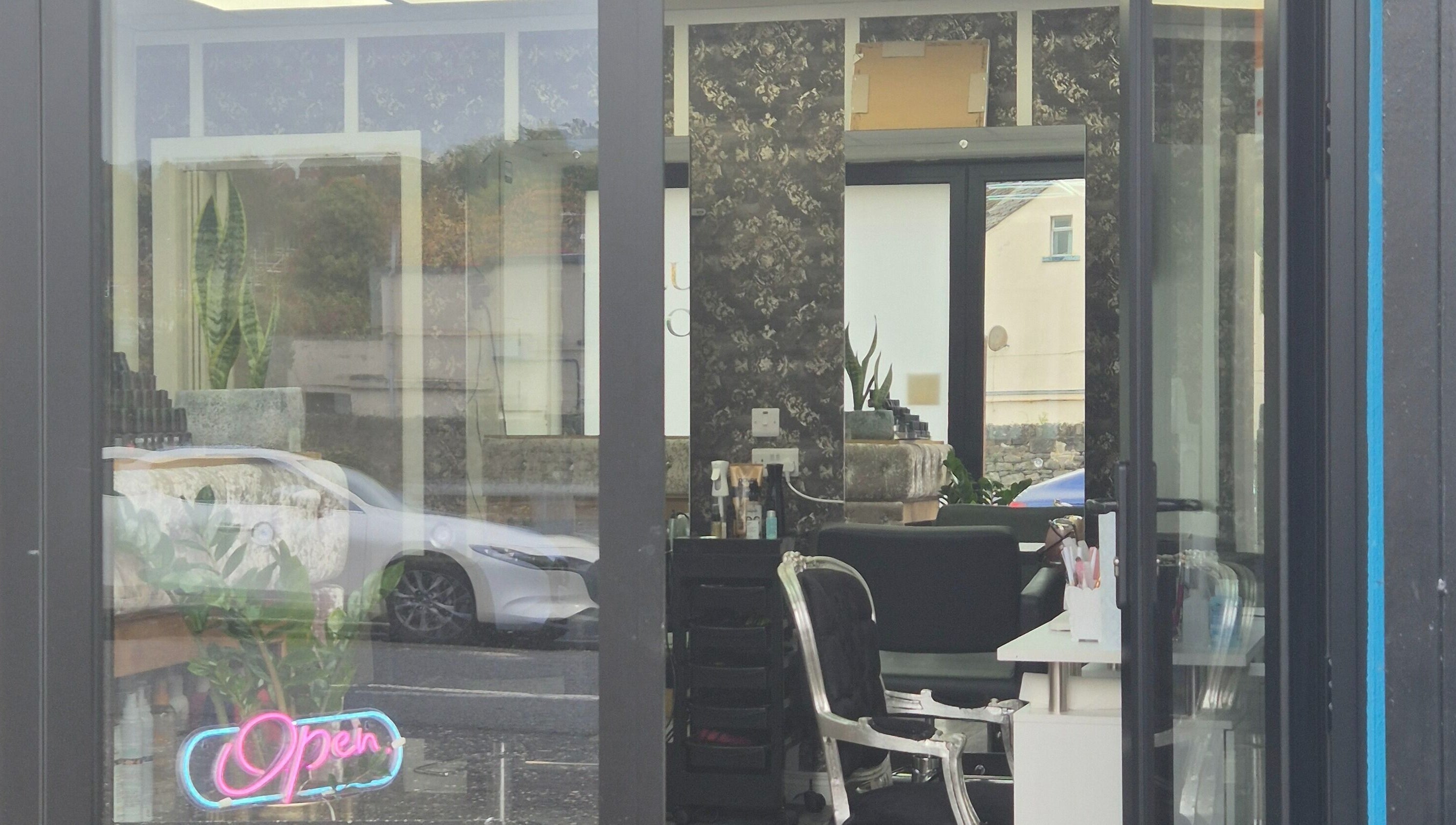 View of D'Lux Salon -Newry, featuring stylish interior and neon 'Open' sign, Newry, Northern Ireland, GB.