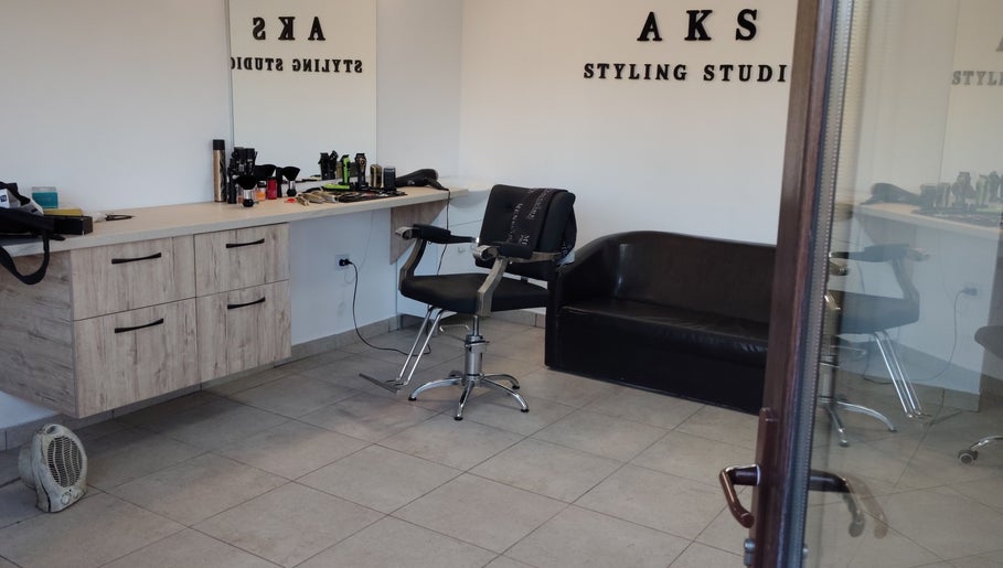 Interior modern la AKS Styling Studio, Leu, Județul Dolj, RO, cu scaun de tuns și canapea.