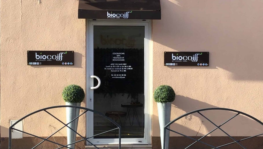 Entrée de la boutique Biocoiff Evreux à Évreux, Normandie, FR, avec enseignes et décorations végétales.