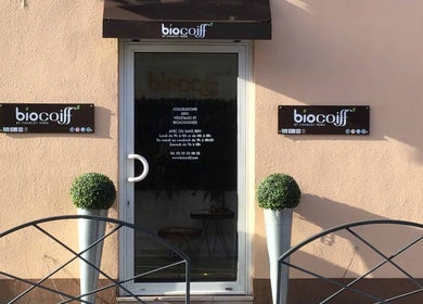 Entrée de la boutique Biocoiff Evreux à Évreux, Normandie, FR, avec enseignes et décorations végétales.