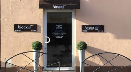 Entrée de la boutique Biocoiff Evreux à Évreux, Normandie, FR, avec enseignes et décorations végétales.