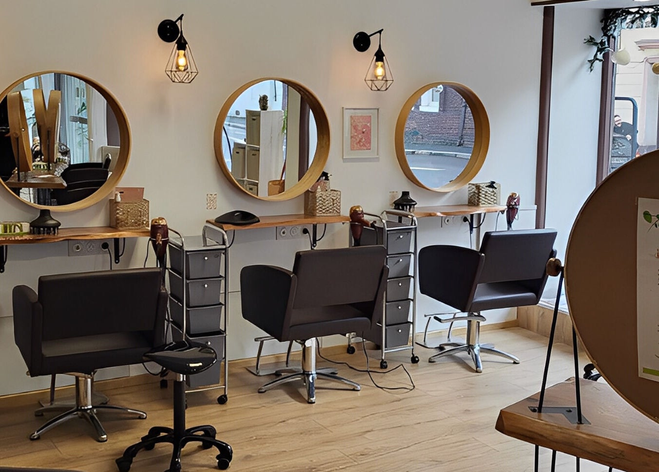 Intérieur moderne de Biocoiff Rouen à Rouen, Normandie, FR avec miroirs circulaires et chaises confortables.