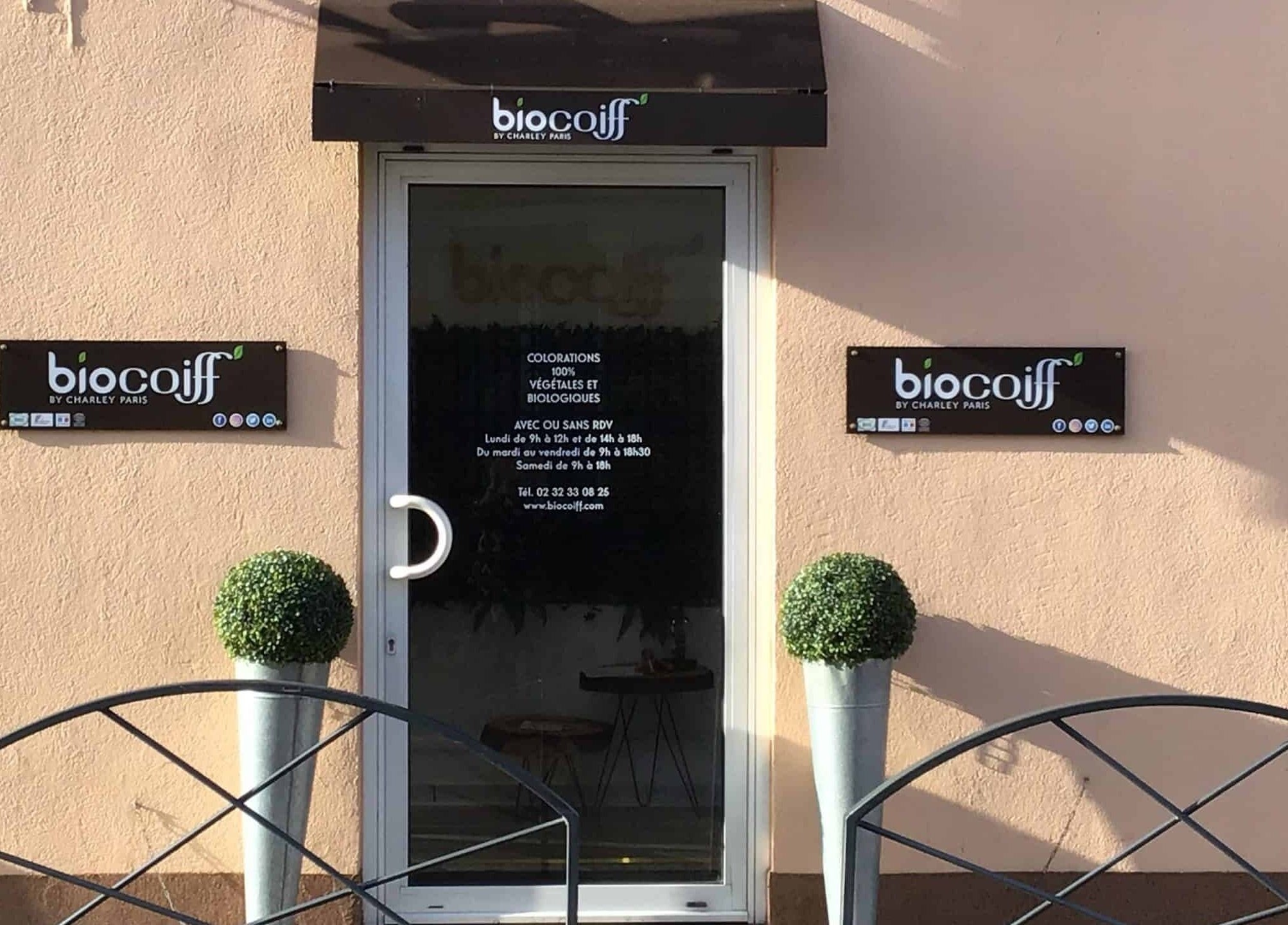 Entrée de Biocoiff Evreux à Évreux, Normandie, FR avec panneau et décor végétal.