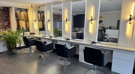 Stylish interior of Erdem Hair London in London, England, GB with black chairs and modern lighting.