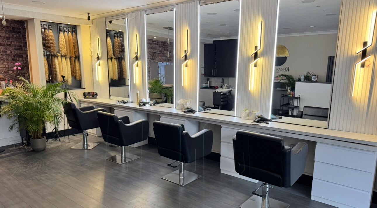 Stylish interior of Erdem Hair London in London, England, GB with black chairs and modern lighting.