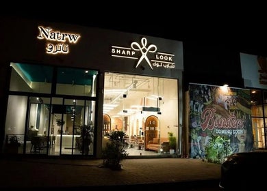 Night view of شارب لوك Sharp Look salon in Riyadh, Riyadh Province, SA, showcasing modern exterior.