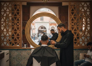 A stylist at Fitrah Men Center in Marrakech, Marrakech-safi, MA, provides a haircut in a beautifully decorated salon.