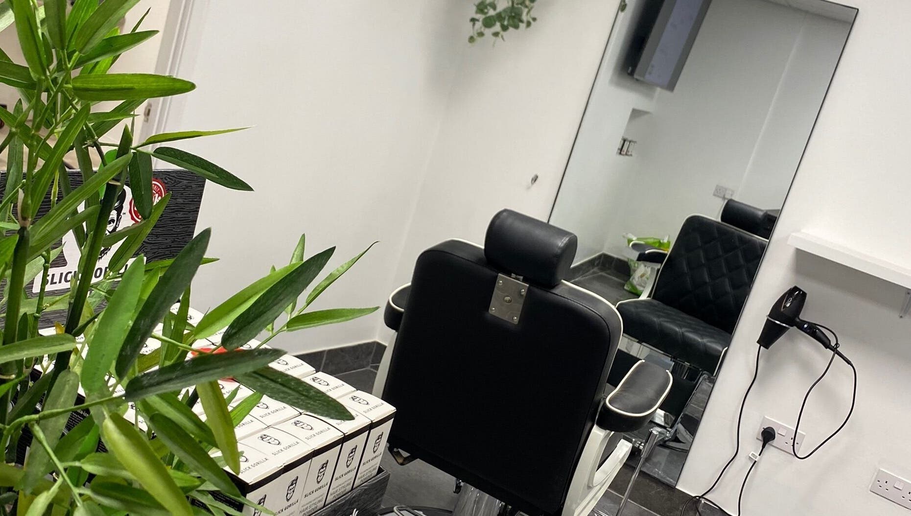 Interior view of Charles Maclean Elite salon showing a stylish chair and mirror in Bridgwater, England, GB.