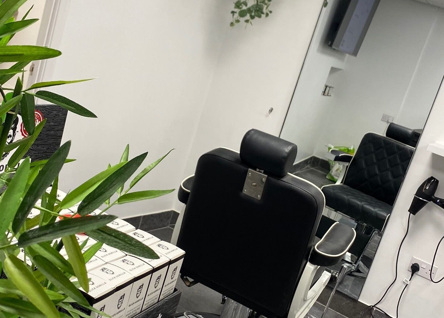Interior view of Charles Maclean Elite salon showing a stylish chair and mirror in Bridgwater, England, GB.