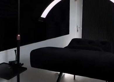 Modern beauty treatment room at Ré-luxe Beauty, Mitcham, England, GB, featuring sleek black furniture and lighting.
