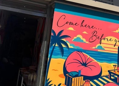 Colorful tropical mural at Lunar Lines, Newhaven, England, GB with palm trees and beach sunset.