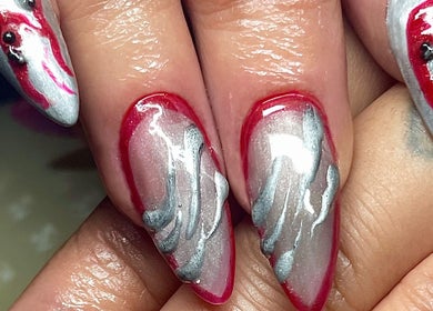 Detailed nail art design at Studio Kay at Gloss and Glow, Il-Mosta, MT, featuring vibrant red and silver patterns.