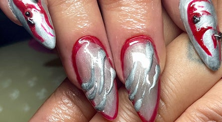 Detailed nail art design at Studio Kay at Gloss and Glow, Il-Mosta, MT, featuring vibrant red and silver patterns.