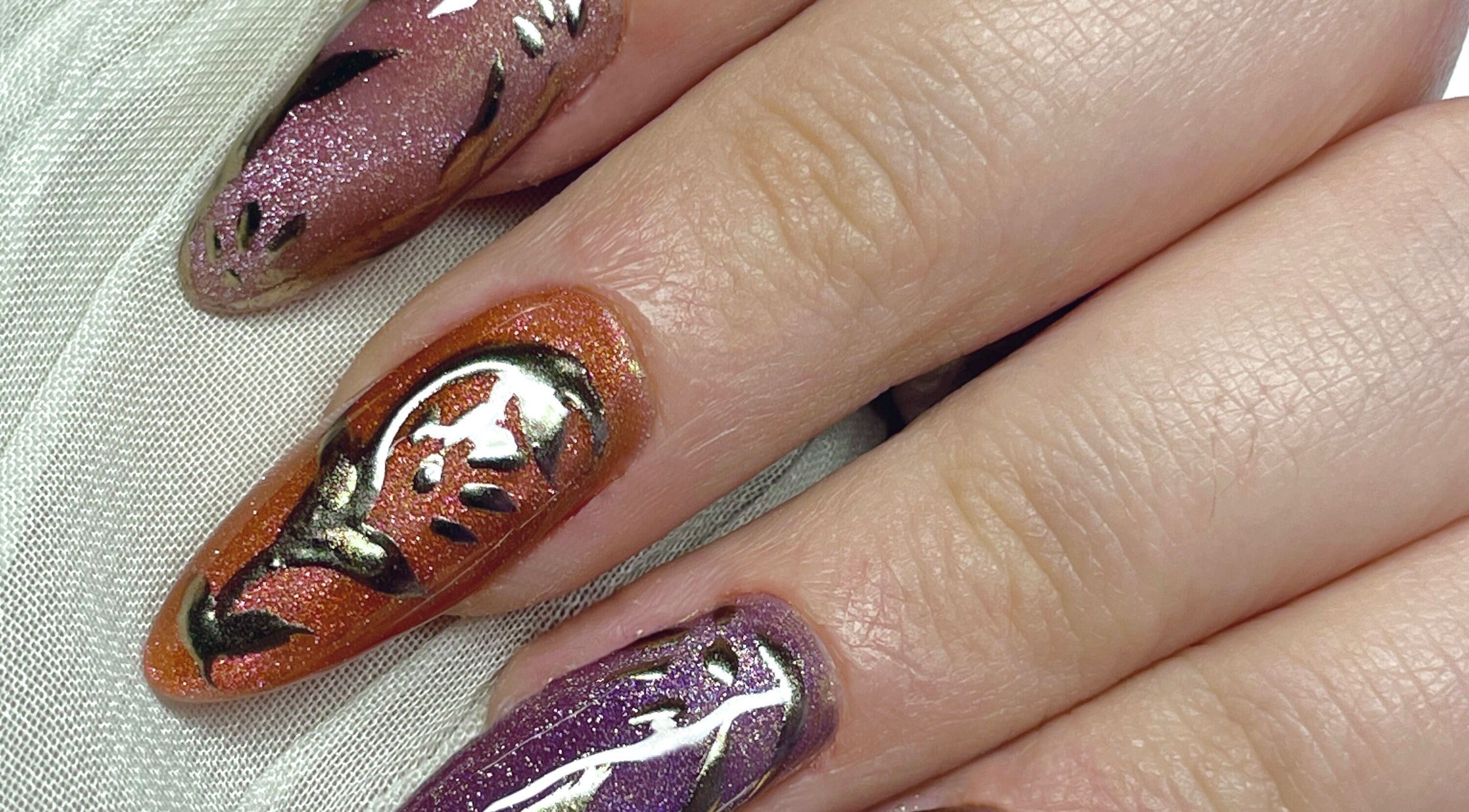 Intricate nail art at Studio Kay At Gloss and Glow, Il-Mosta, MT, showcasing detailed designs in purple and orange.
