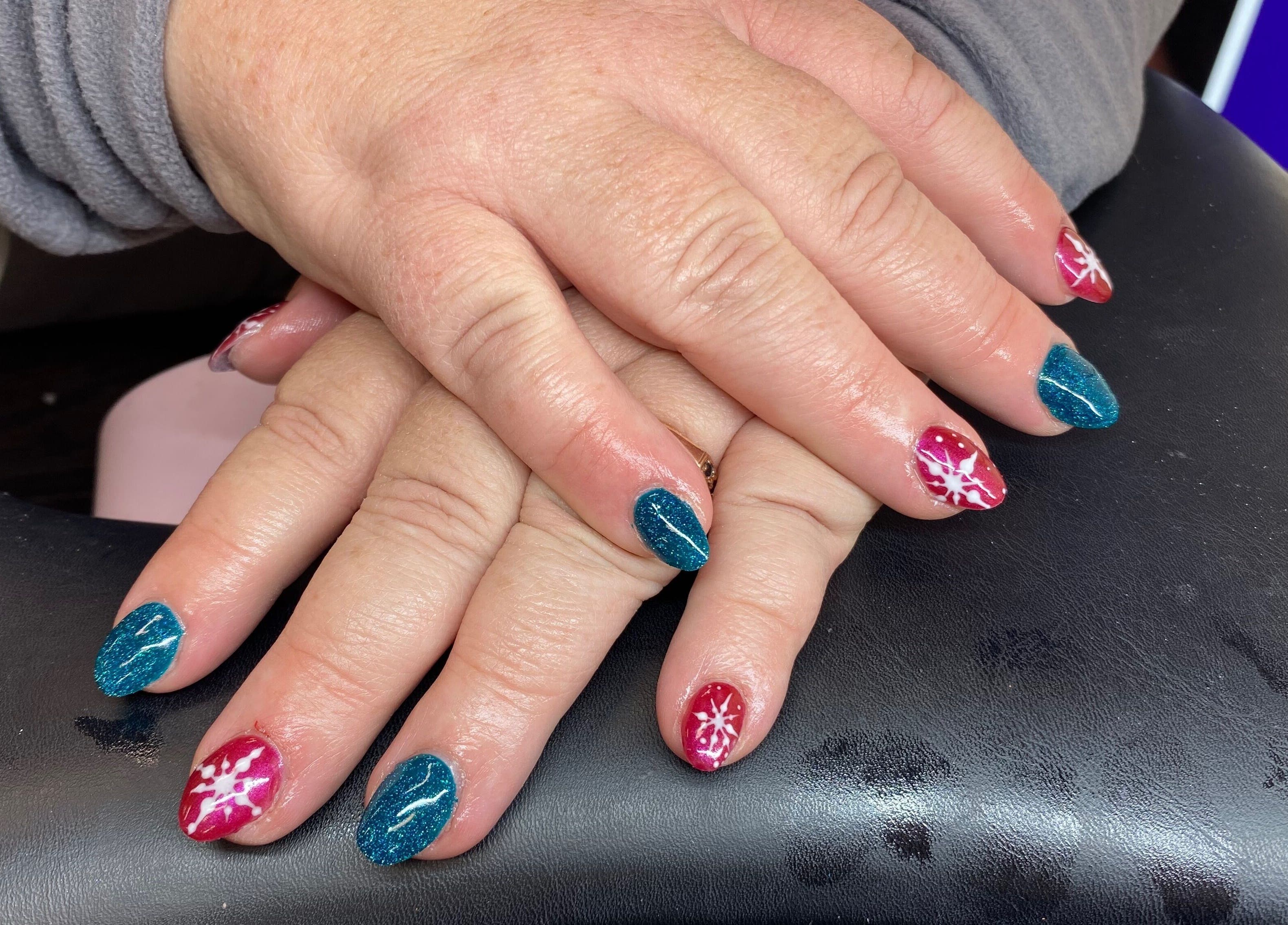 Colorful blue and red festive nail art at Arch Design Beauty in Tamworth, England, GB.