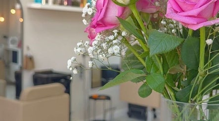 Pink roses in vase at FreyjaMaiHair, Derby, England, GB salon for a touch of elegance.