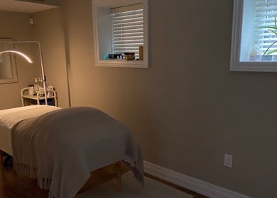 Peaceful treatment room at The Glowing Angel in Toronto, Ontario, CA with ambient lighting and massage table.
