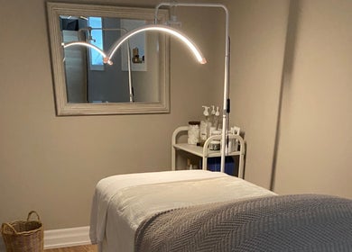 Calm massage room at The Glowing Angel in Toronto, Ontario, CA featuring a cozy treatment bed and ambient lighting.
