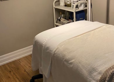 Peaceful treatment room at The Glowing Angel, Toronto, Ontario, CA, featuring a cozy spa bed and products.