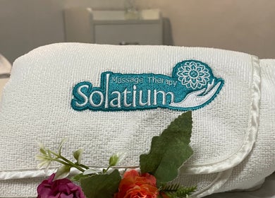 Toalla bordada de Solatium Centro de Terapia Física en Oaxaca De Juárez, Oaxaca, MX con decoración floral.