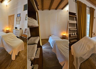 Sala de tratamiento acogedora en Donde los Yayos de Barcelona, Barcelona, Catalunya, ES con camilla y decoración cálida.