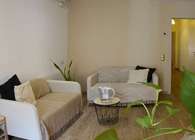 Sala acogedora en donde los yayos de barcelona, Barcelona, Catalunya, ES con sofás y plantas.