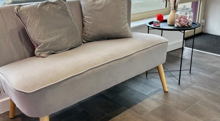 Comfy grey couch and table setup at Lashandblowbarx, Widnes, England, GB, showcasing elegance and comfort.