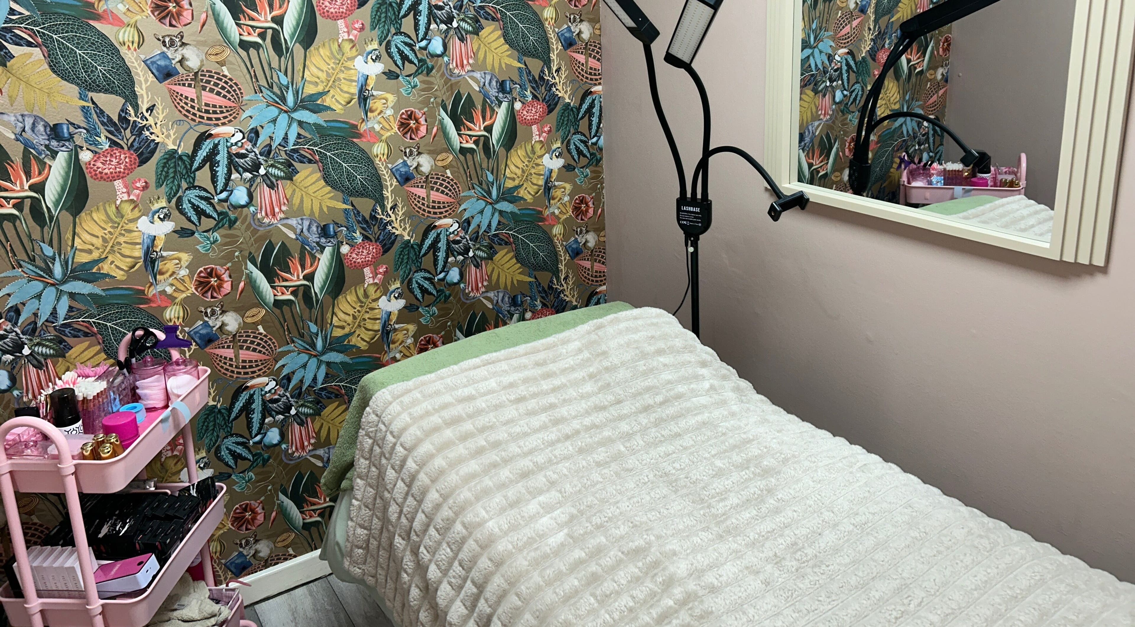 Cozy treatment area at Lashandblowbarx, Widnes, England with vibrant decor and a comfortable bed.