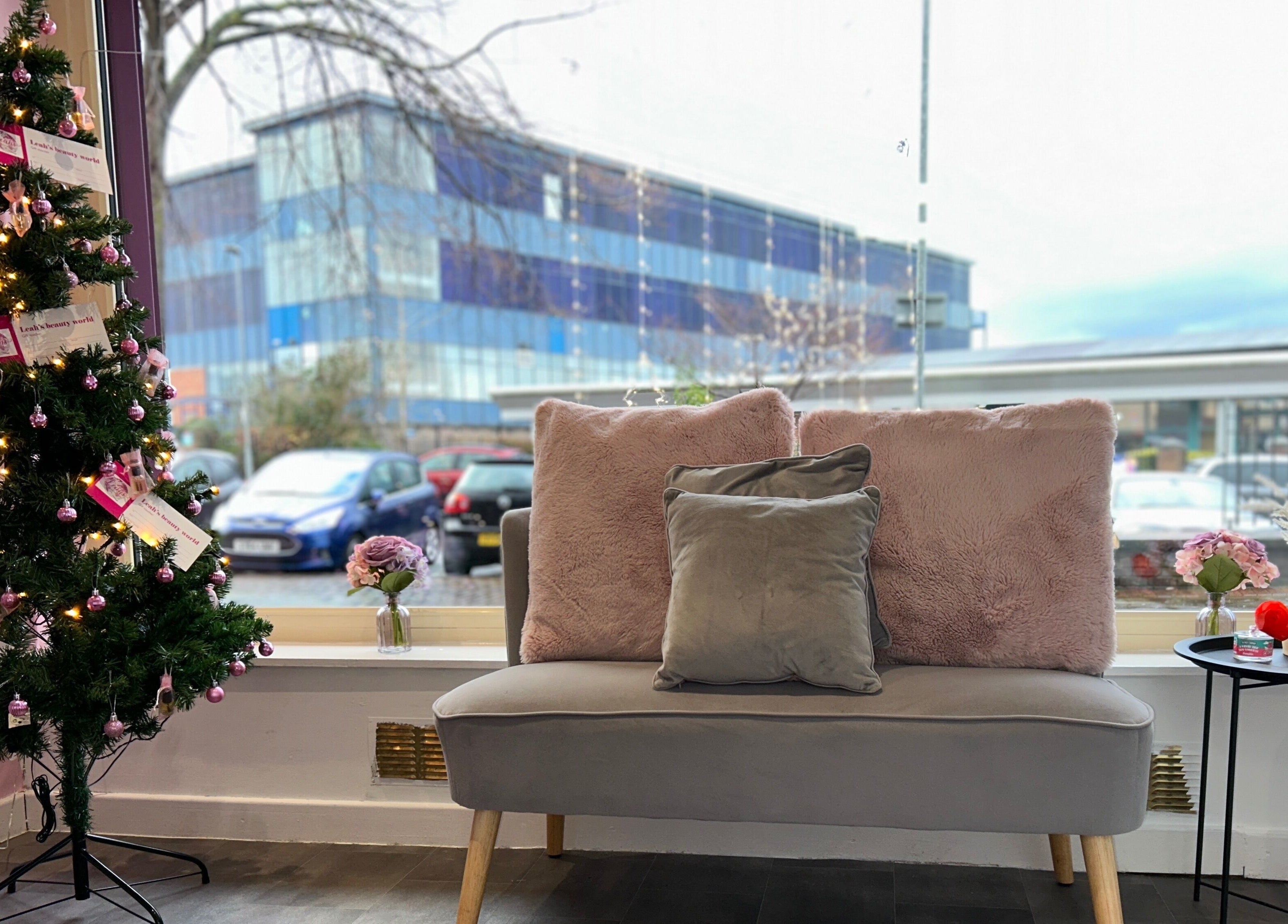 Lashandblowbarx, Widnes, England, GB lounge area with plush sofa and decor near a decorated tree.