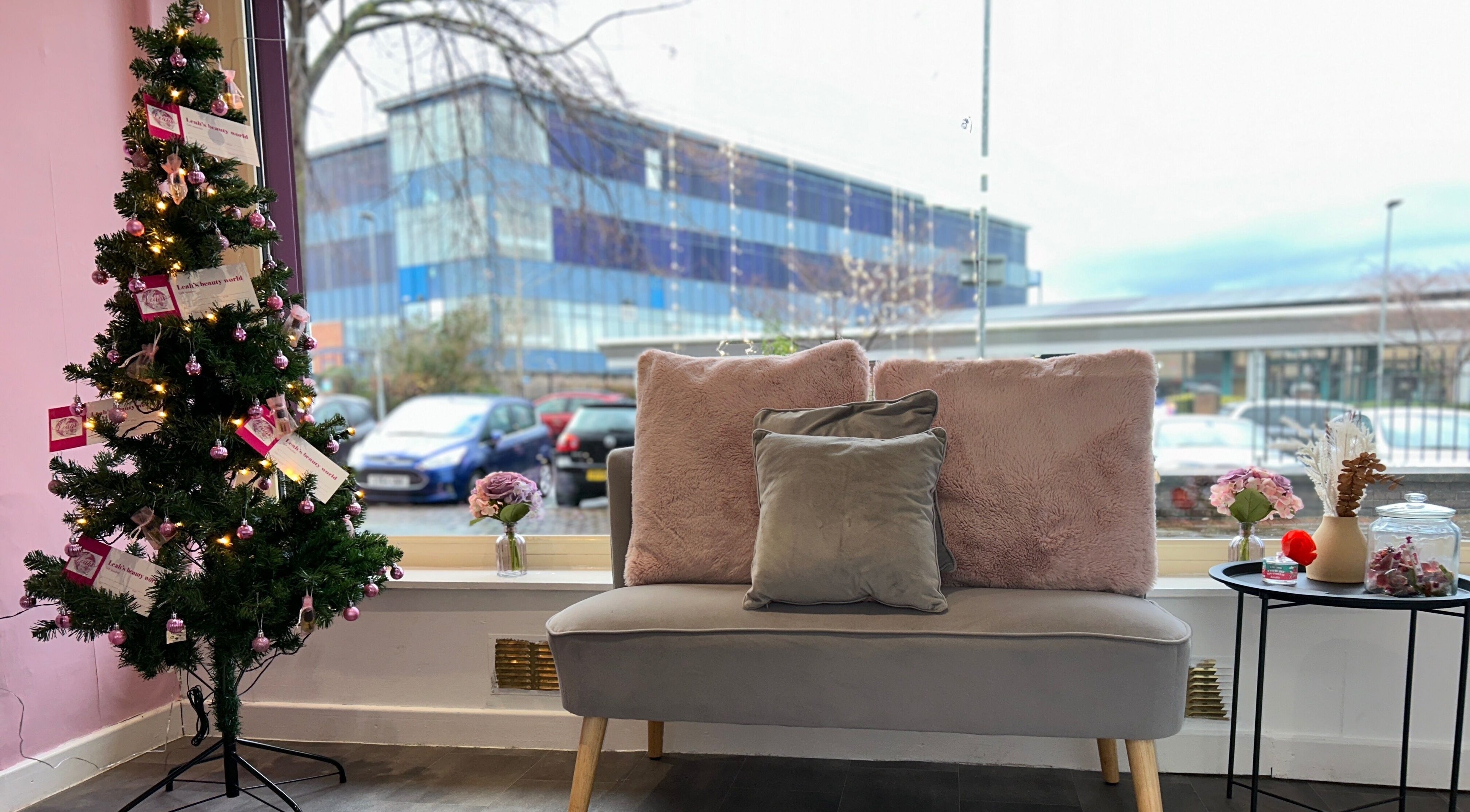 Lashandblowbarx, Widnes, England, GB lounge area with plush sofa and decor near a decorated tree.