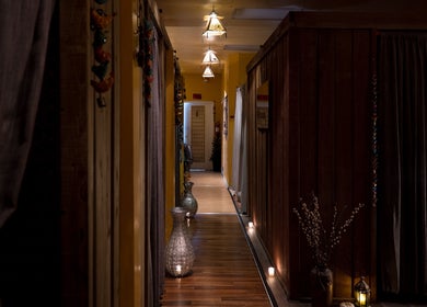 Dimly lit hallway with decor leading to rooms at The ZenSai Spa, Burbank, California, US.