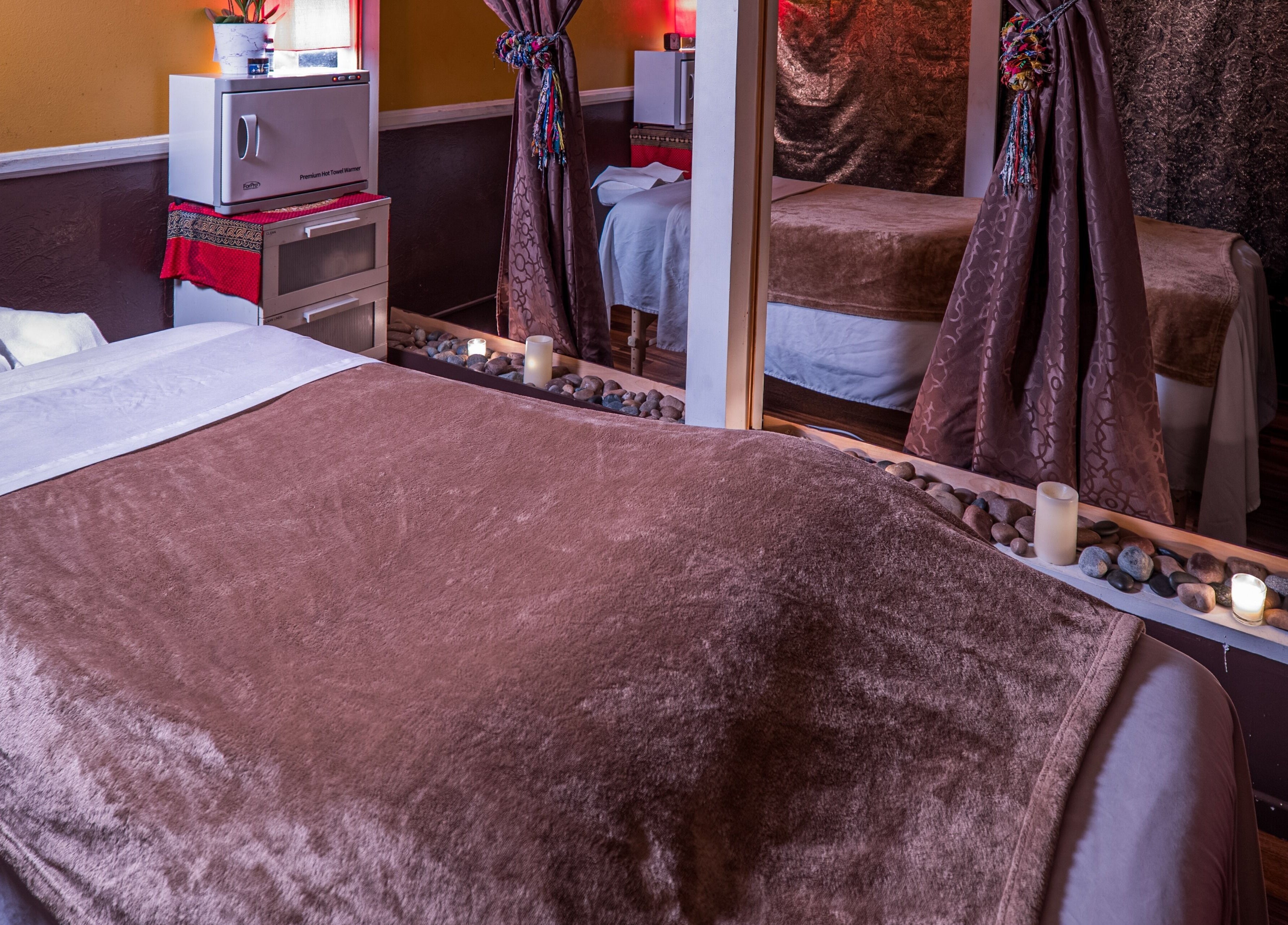 Tranquil massage room at The ZenSai Spa, Burbank, California, US, featuring plush bedding and ambient lighting.