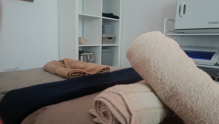 Relaxing massage table setup at HoVana Holistics & Beauty, Glasgow, Scotland, GB with neatly folded towels.