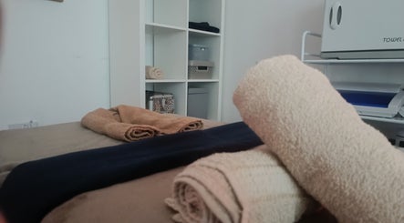 Relaxing massage table setup at HoVana Holistics & Beauty, Glasgow, Scotland, GB with neatly folded towels.