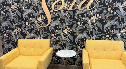 Stylish seating area at Men's Grooming Lounge By Mel, Mission Viejo, California, US with floral wallpaper.