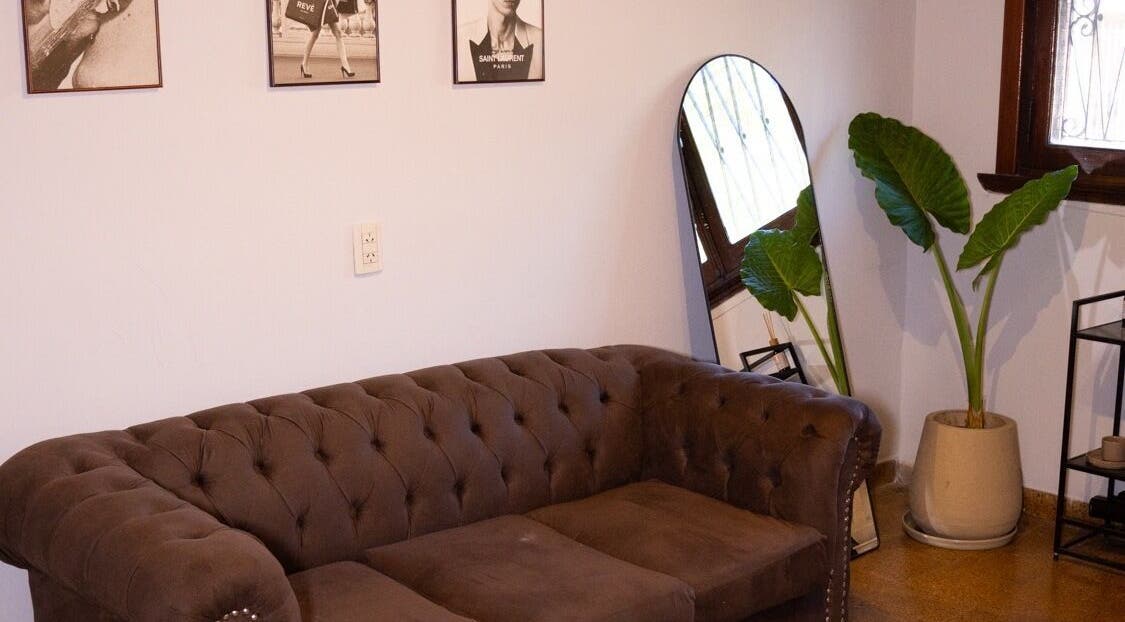 Sala de espera elegante con sofá en Revé Salon, Lanús, Provincia De Buenos Aires, AR.