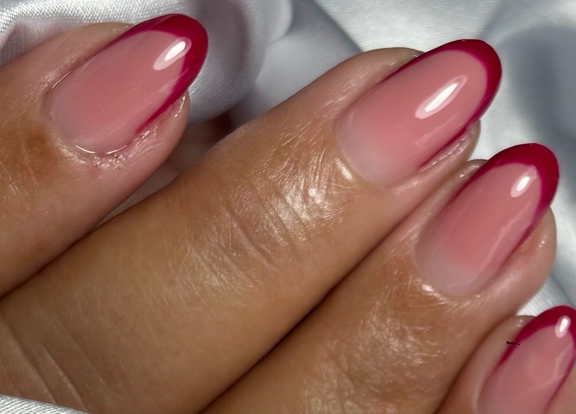 Glossy crimson-tipped nails at NailVow, Willemstad, Curaçao, CW showcase elegance and style.