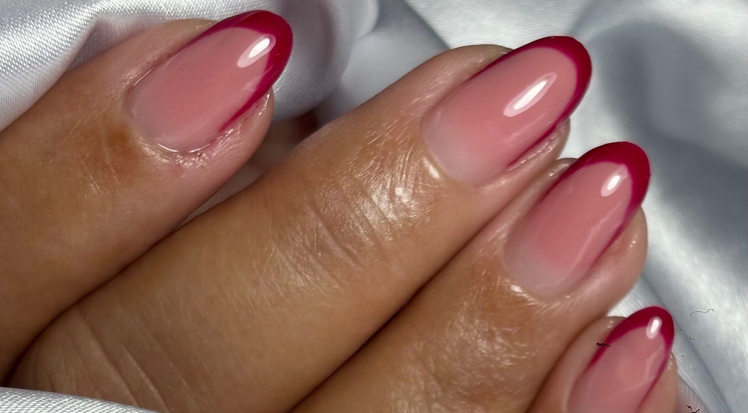 Glossy crimson-tipped nails at NailVow, Willemstad, Curaçao, CW showcase elegance and style.