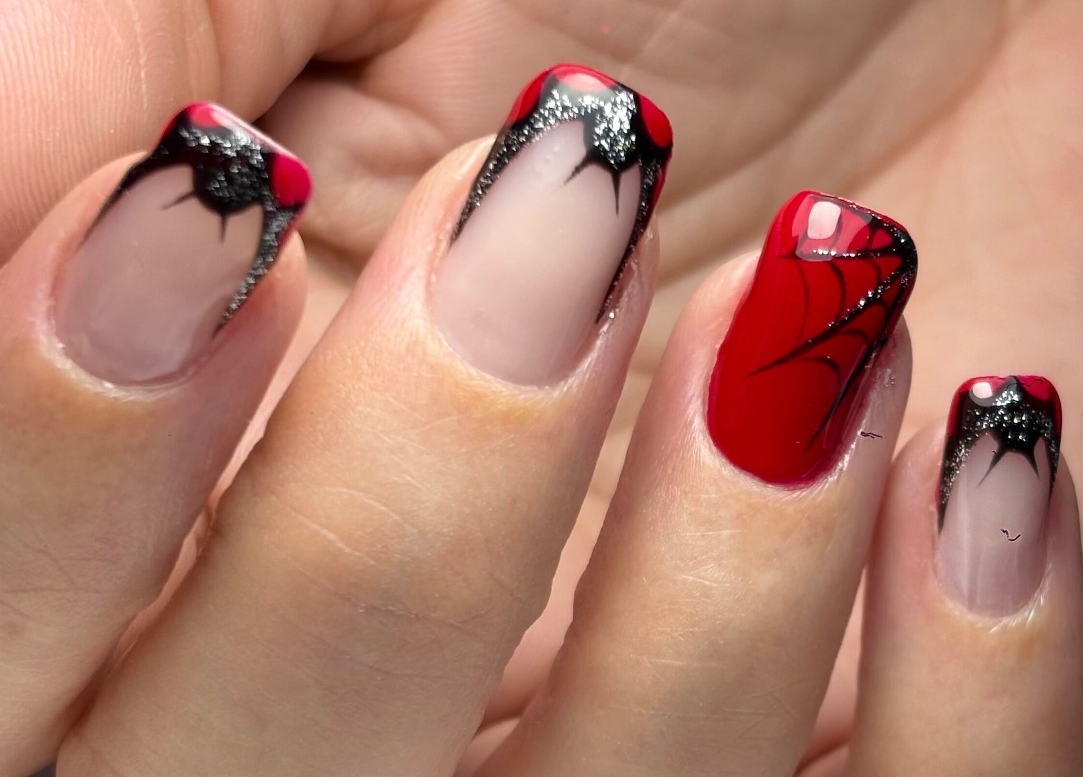 Intricate spider-themed red and black nail art at NailVow, Willemstad, Curaçao, CW.