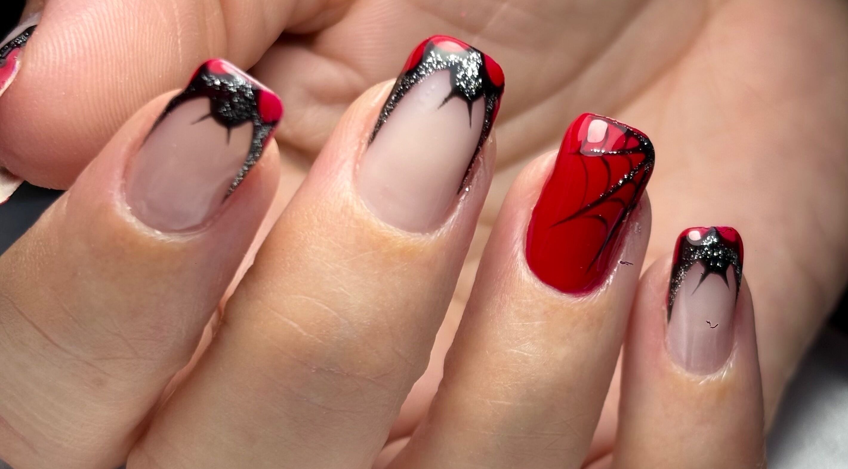 Intricate spider-themed red and black nail art at NailVow, Willemstad, Curaçao, CW.