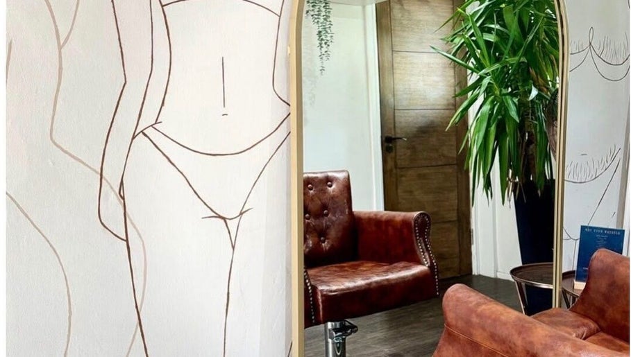 Elegant lounge at Styled by Beth, Bromsgrove, England, GB, featuring a leather chair and artistic walls.
