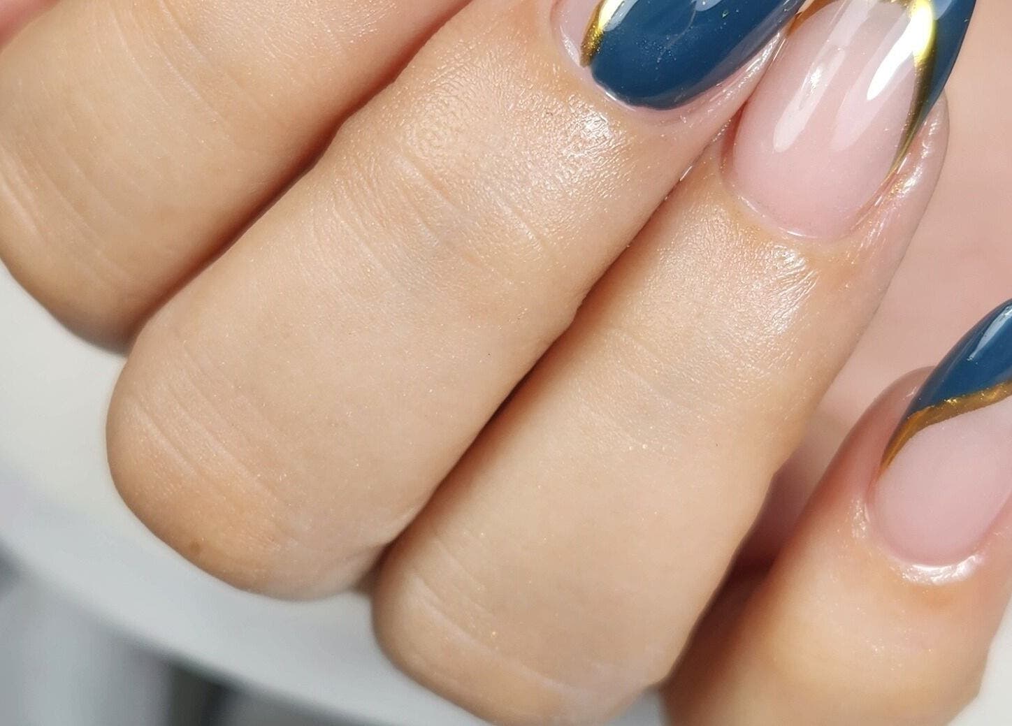 Diseño de uñas azul y dorado en Eliz Nails Studio, Willemstad, CW. Manicura elegante y profesional.